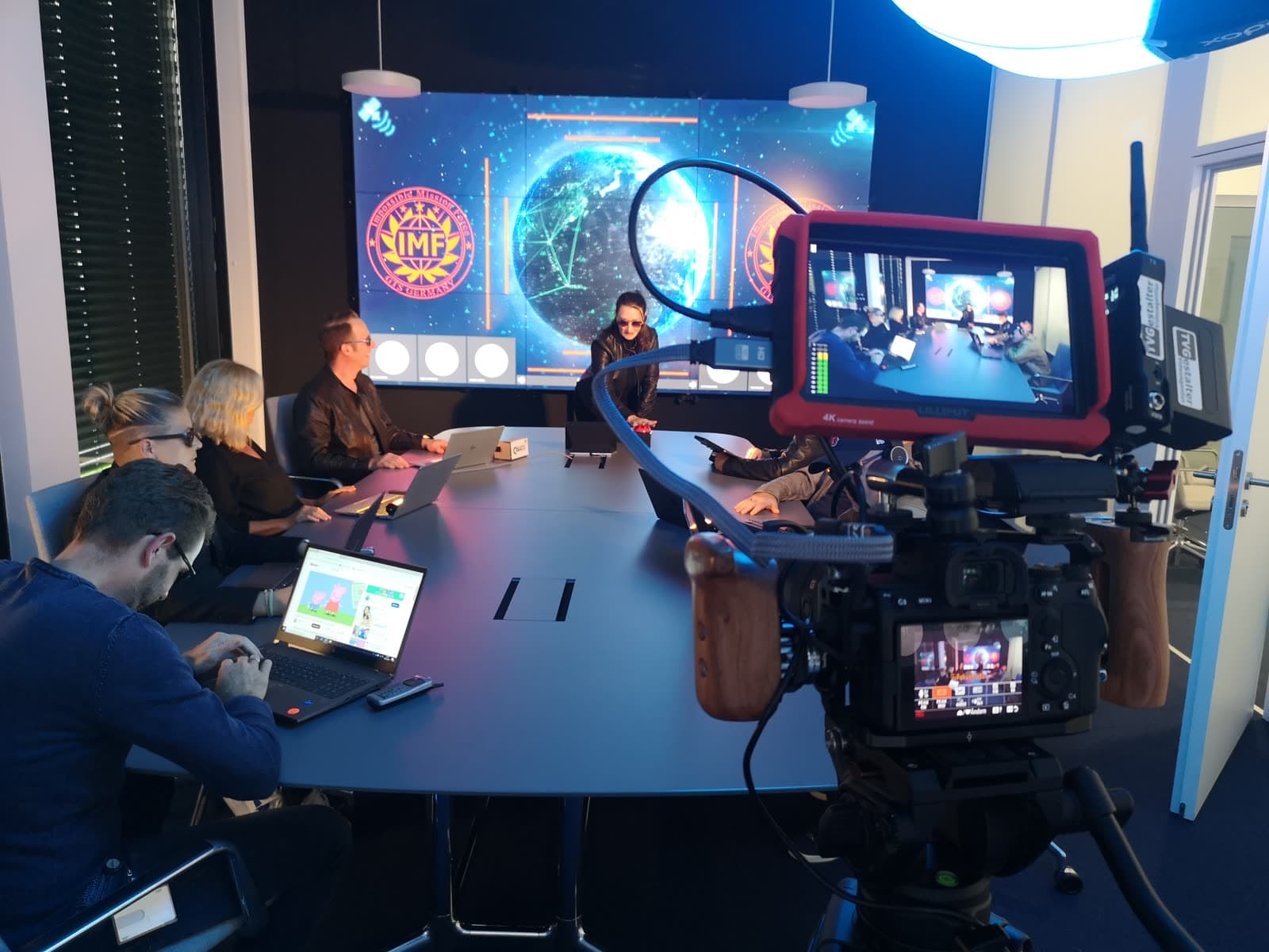 Studio-Setup mit Weltkarten-Screen während einer Produktion